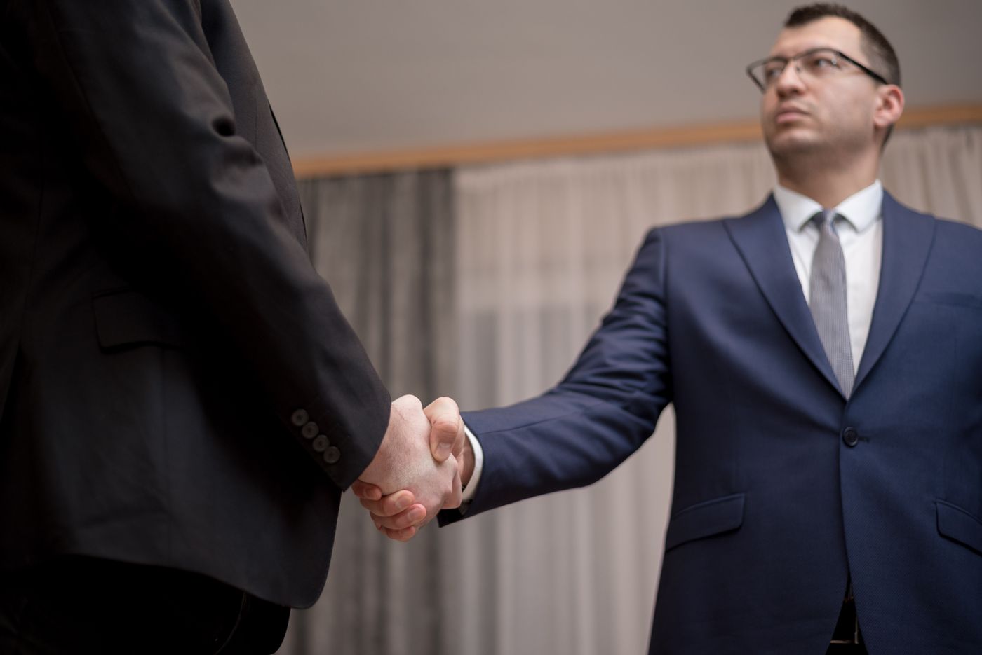Two people in suits shaking hands.
