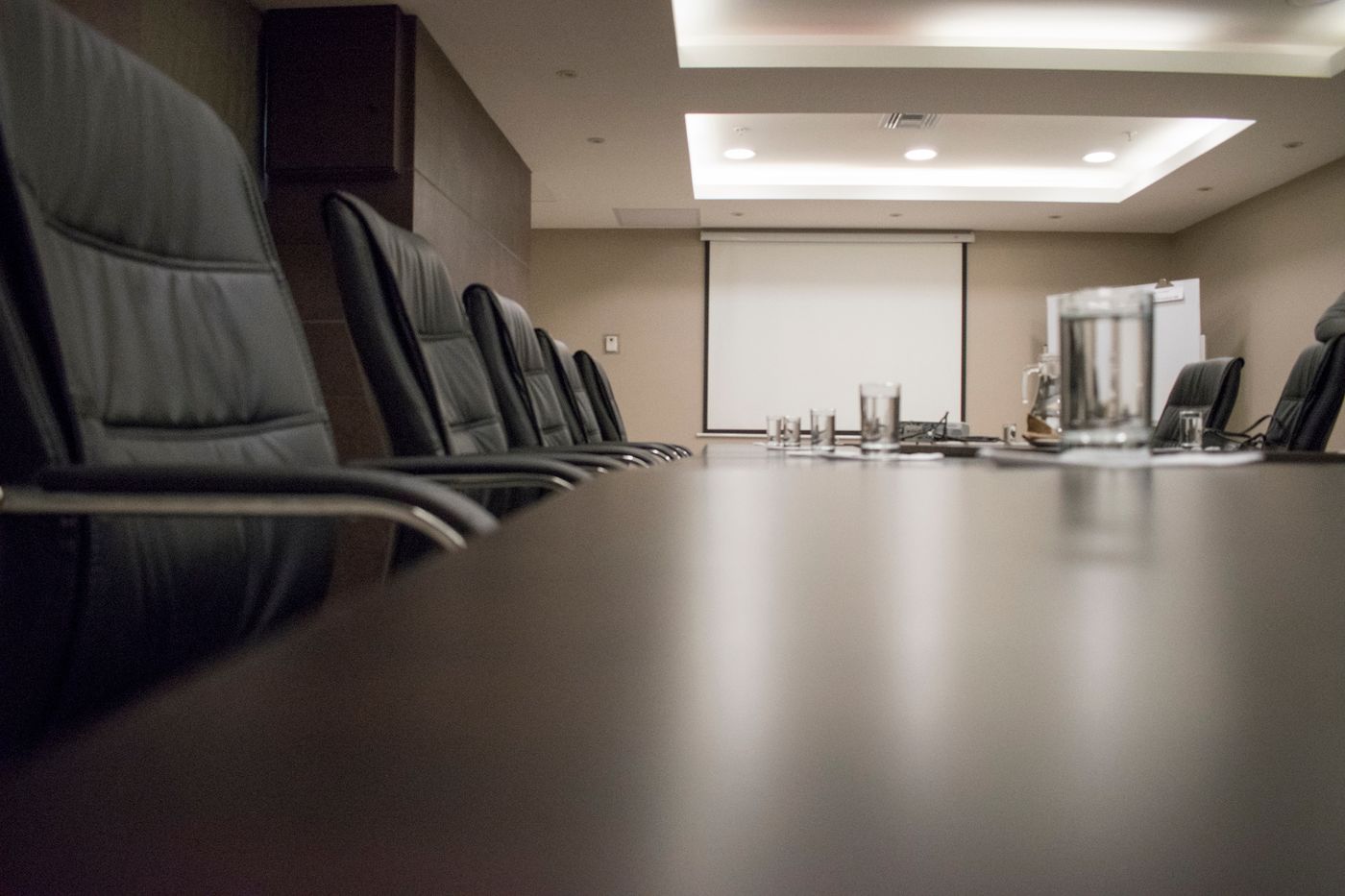 An empty boardroom with a long table and chairs before a meeting.