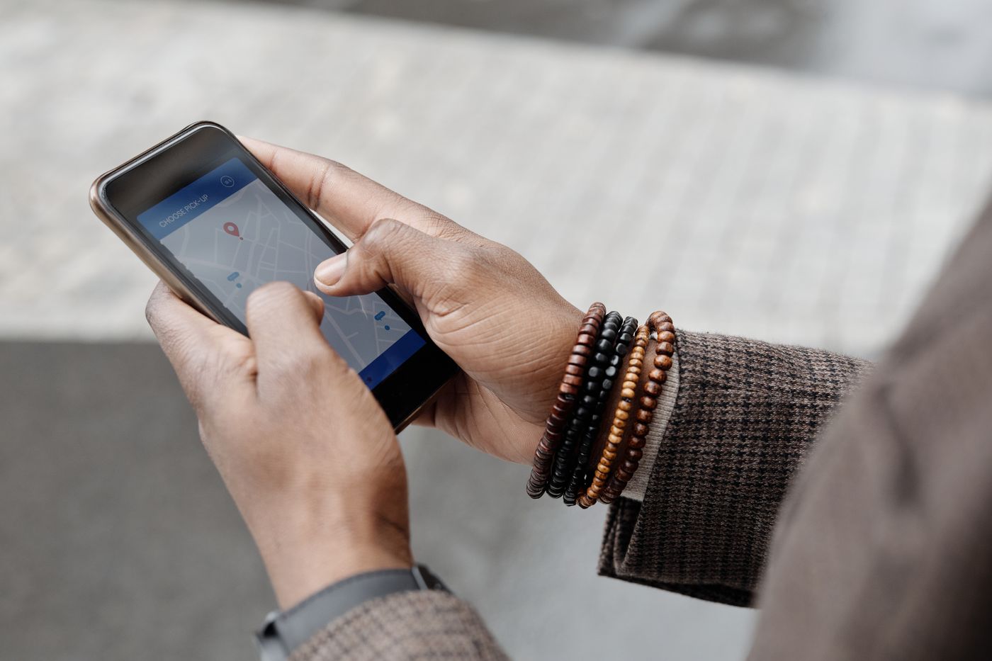 Two hands holding a phone that shows a street map with a location pin.