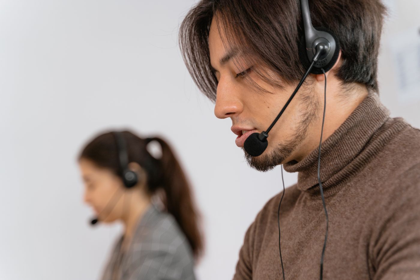 A call handler wearing a headset at a desk, taking a call.