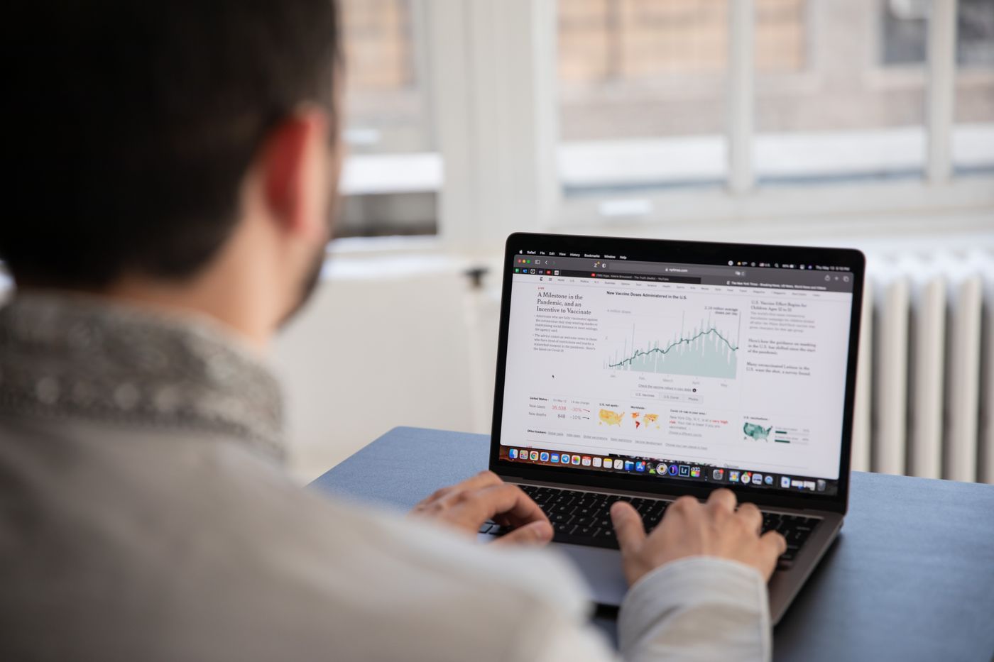 A person working at a laptop with data on the screen.