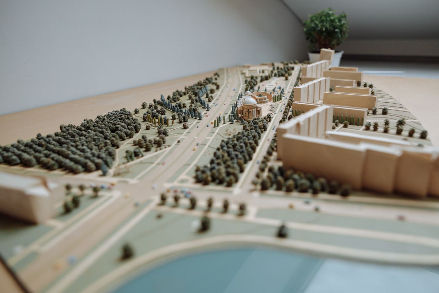 A detailed scale model of a city district — model trees, roads and blocks of buildings on a table.
