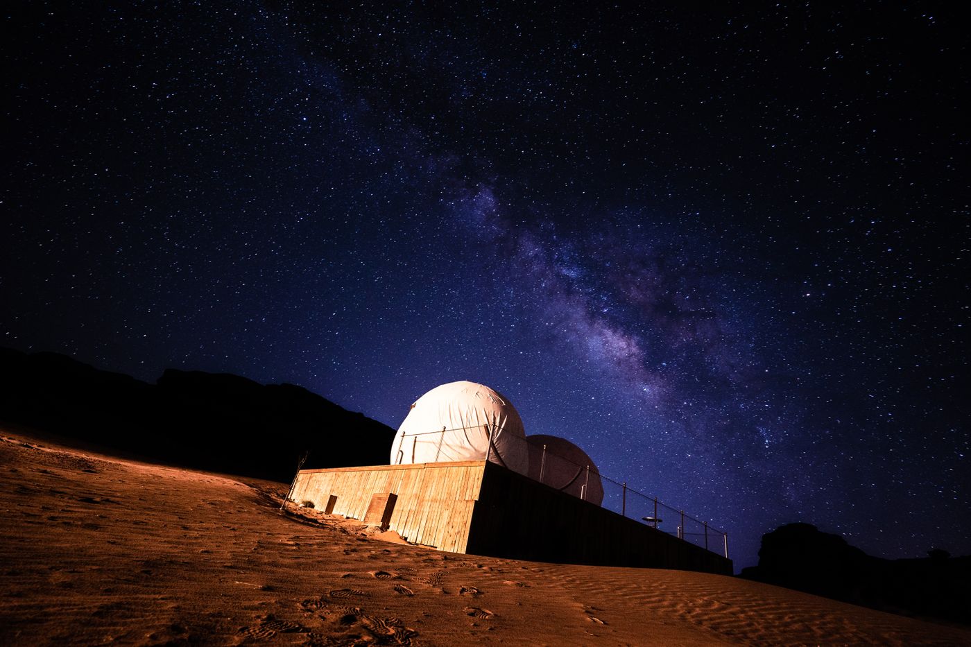A telescope pointed at a night sky from an observatory.