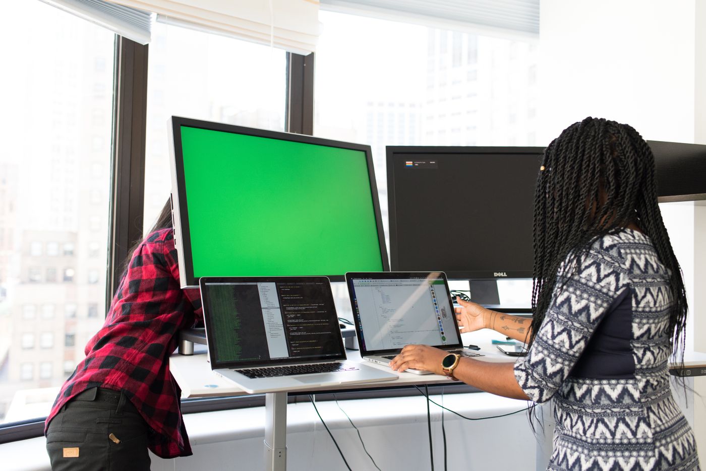 A software team working at desks with monitors showing dashboards.